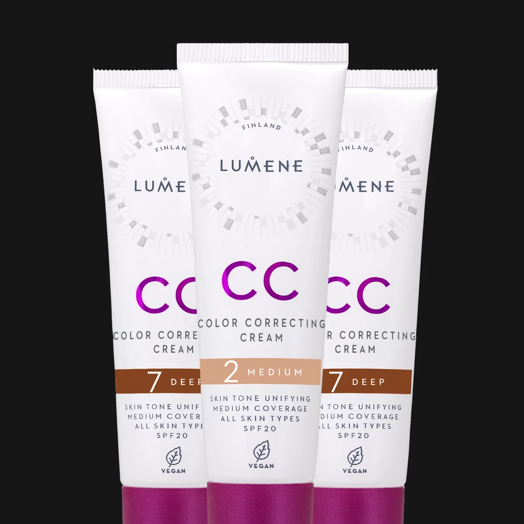 Kolme Lumene CC Color Correcting Cream -voidetta eri sävyissä, kuten 2 Medium ja 7 Deep, on asetettu riviin mustaa taustaa vasten.