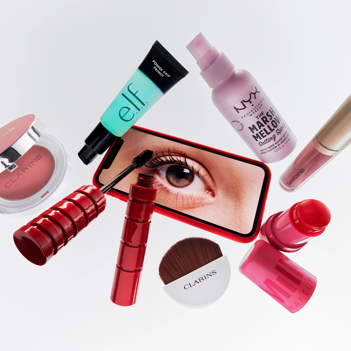  En bild av olika sminkprodukter, inklusive en läppstift och en mascara, mot en vit bakgrund.