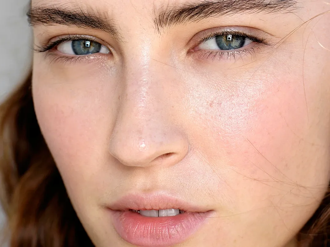 Person med blå øyne og strålende hud.