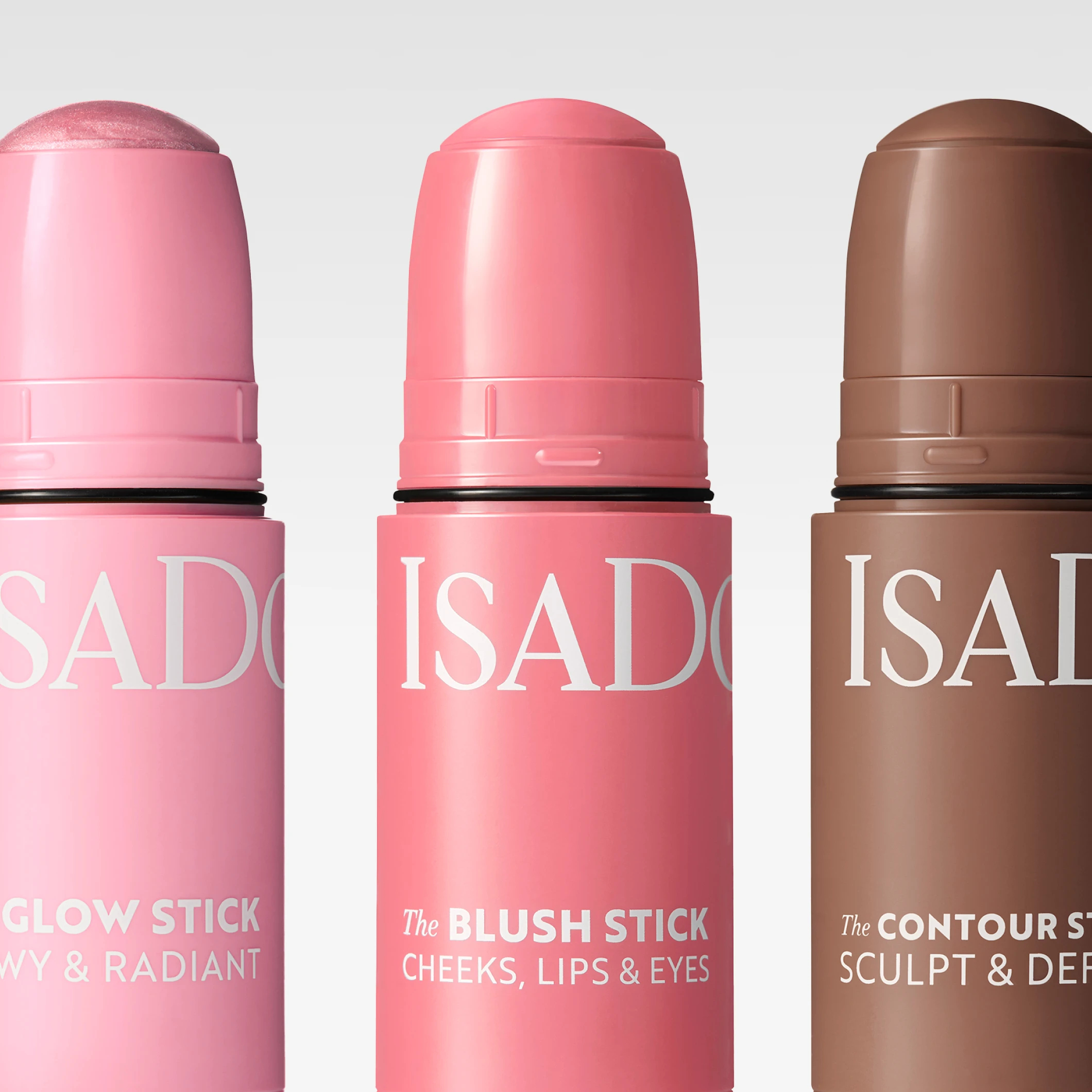 Lähikuva ISADORA-meikkipuikoista: “Glow Stick Dewy & Radiant”, “Blush Stick Cheeks, Lips & Eyes” ja “Contour Stick Sculpt & Define”, näkyvällä ISADORA-tekstillä ja sävytetyillä kärjillä.