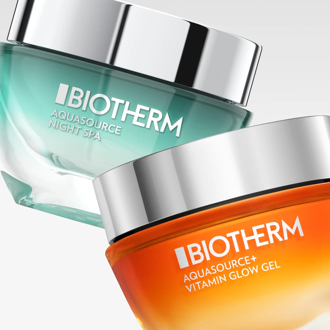 Biotherm Aquasource Night Spa och Biotherm Aquasource+ Vitamin Glow Gel hudvård i glasburkar med silverfärgade lock. Produktnamnen "BIOTHERM", "AQUASOURCE NIGHT SPA" och "AQUASOURCE+ VITAMIN GLOW GEL" syns tydligt mot en ljus bakgrund.