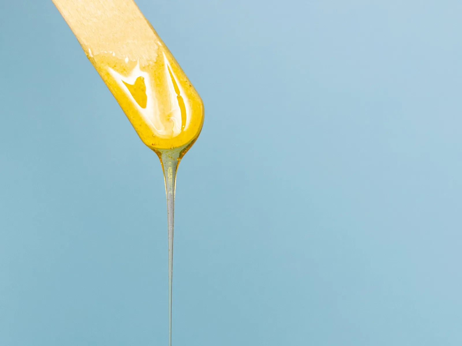 Trespade med dryppende bivoks mot blå bakgrunn