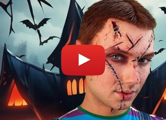 Henkilö, jolla on sateenkaariraidallinen paita halloween-taustan edessä, jossa on lepakoita ja taloja, YouTube-logo kasvojen päällä.