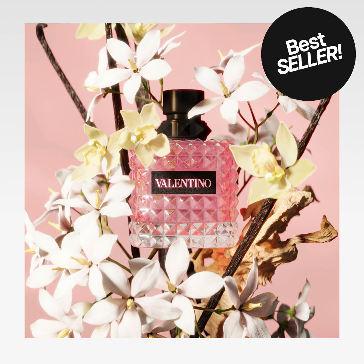 Vaaleanpunainen Valentino-hajuvesipullo, joka on aseteltu kukkien ja oksien keskelle. Kuvassa näkyy myös teksti "Best SELLER!"