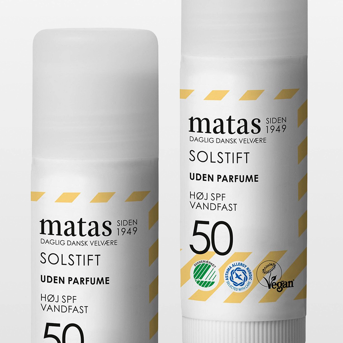 Flera tuber av Matas Solstift SPF 50 med texten “matas SIDEN 1949”, “SOLSTIFT”, “UDEN PARFUME”, “HØJ SPF”, “VANDFAST” samt märkningar som Svanemärket och Asthma Allergy Nordic. Fokus på solskydd, solstift och SPF 50 i vit förpackning med gula detaljer.