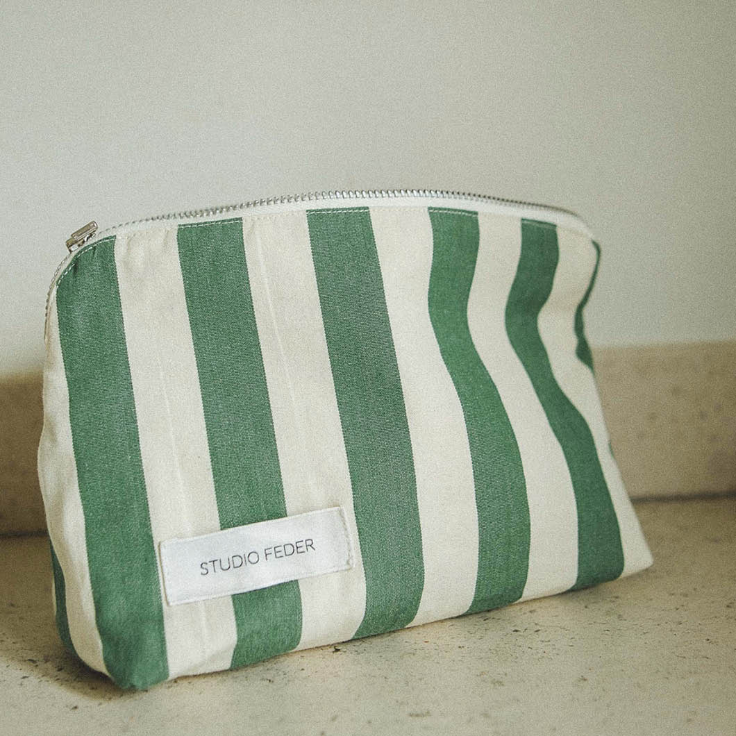 En toalettmappe med hvite og grønne striper.