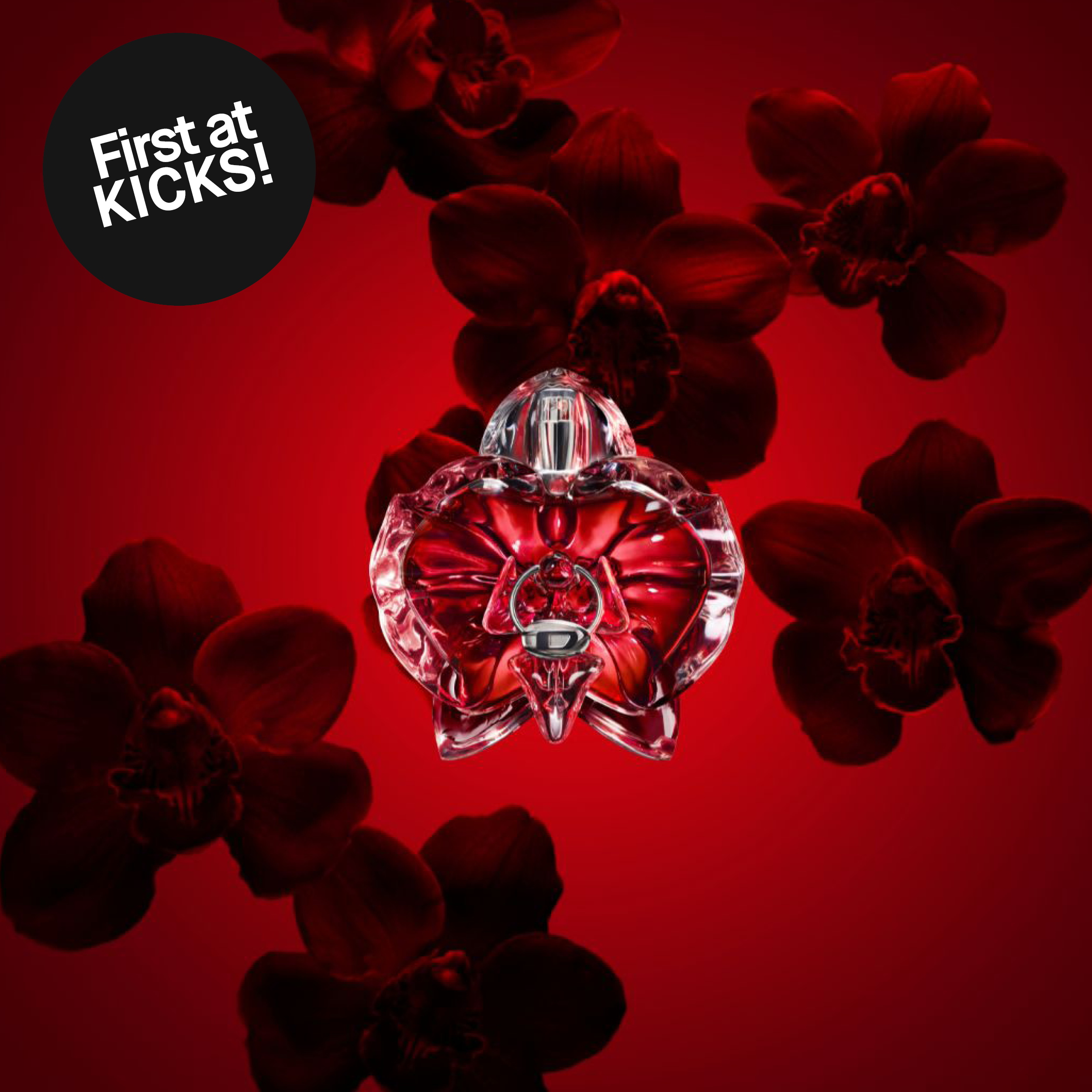 Diesel Loverdose Red Kiss -hajuvesipullo punaisella taustalla tummien orkideoiden edessä. Kuvassa teksti: ”First at KICKS!”.