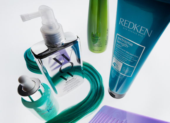 Hårvårdsprodukter med tealfärgat hårstrå och lila kam.