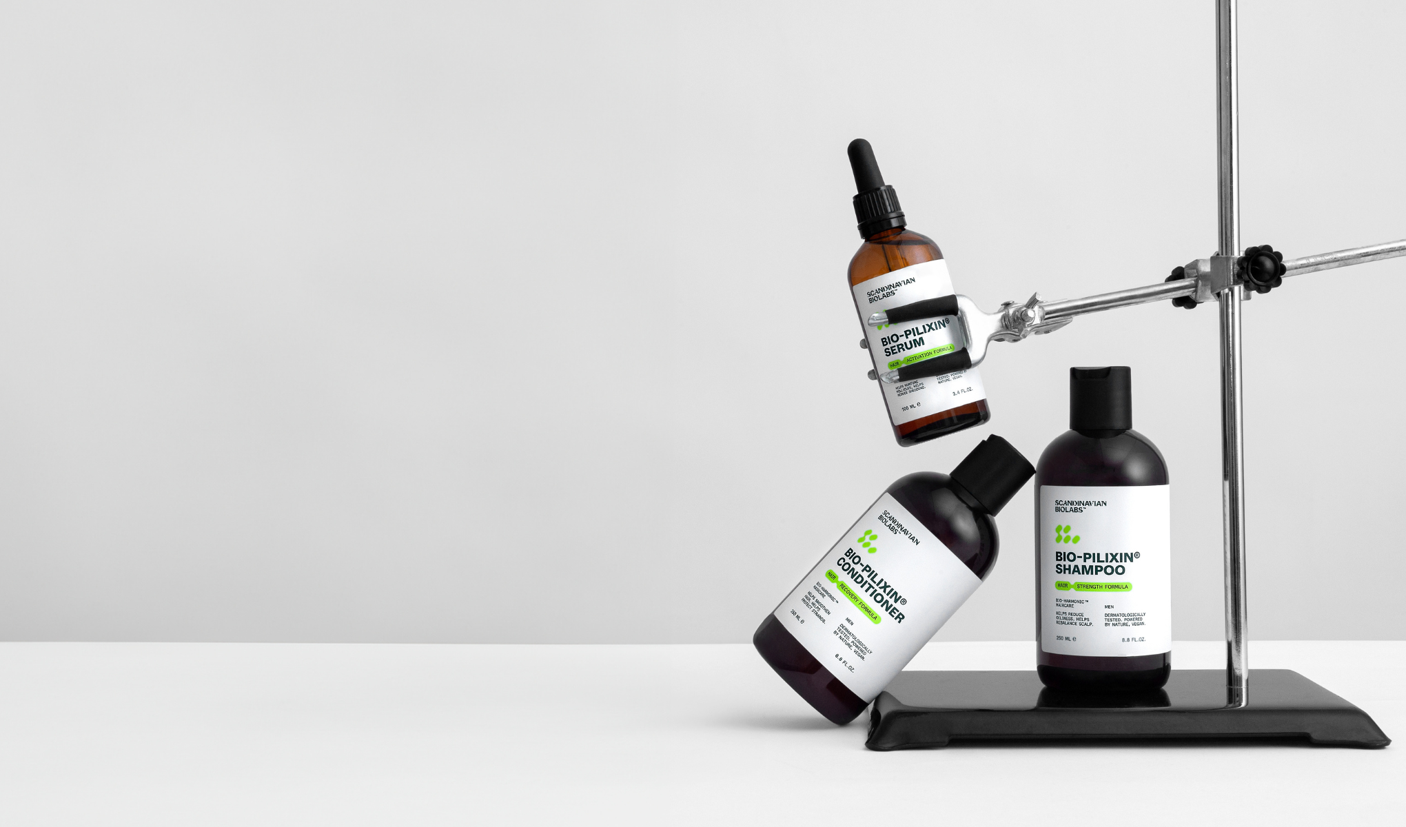 Tre hårpleieprodukter mot en hvit bakgrunn. Øverst en brun flaske "Bio-Pilixin Serum", i midten en svart flaske "Bio-Pilixin Conditioner" og nederst en svart flaske "Bio-Pilixin Shampoo".