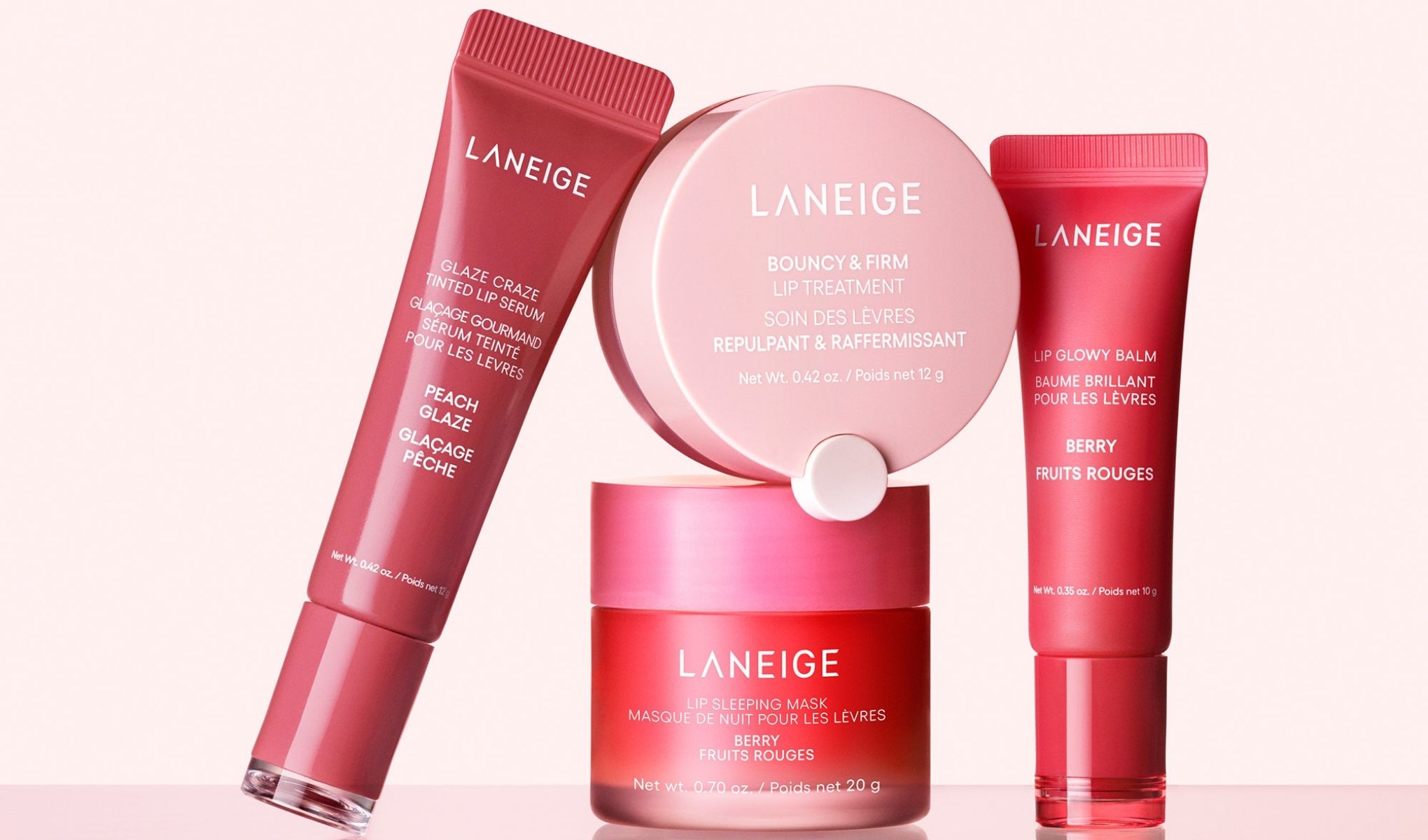 Laneige-produktsamling som inkluderer en leppeserum, leppepomade, leppebehandling og en leppemaske. Produktene har rødlige nyanser og tekst på både engelsk og fransk.