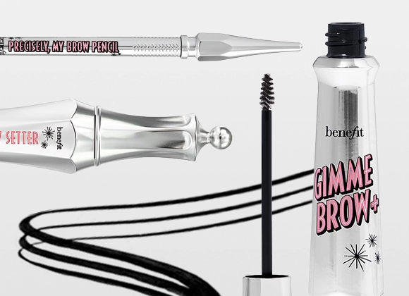 Närbild av ögonbrynsprodukter från Benefit, inklusive Gimme Brow+ bryngel i transparent flaska med rosa text, Precisely, My Brow Pencil och Brow Setter. Svart brynborste och dragna brynlinjer syns mot ljus bakgrund.