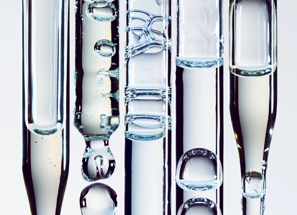 Pipetter mot ljusgrå bakgrund med olika transparenta serum.