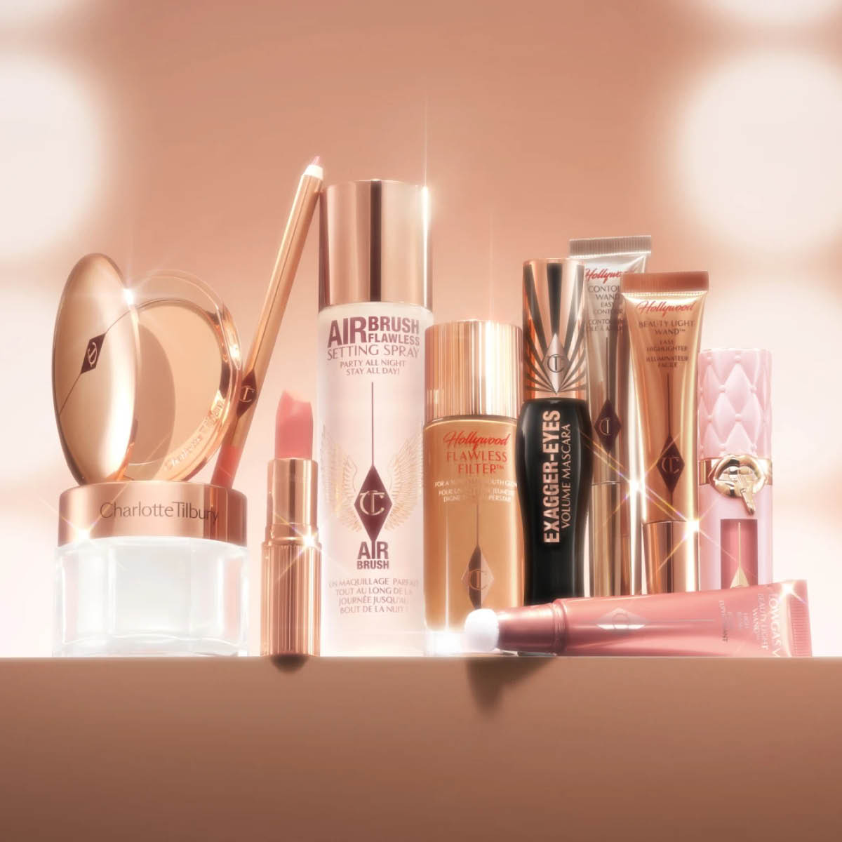 flere makeupprodukter fra charlotte tilbury i duse farger står samlet med "hollywood"-lys rundt