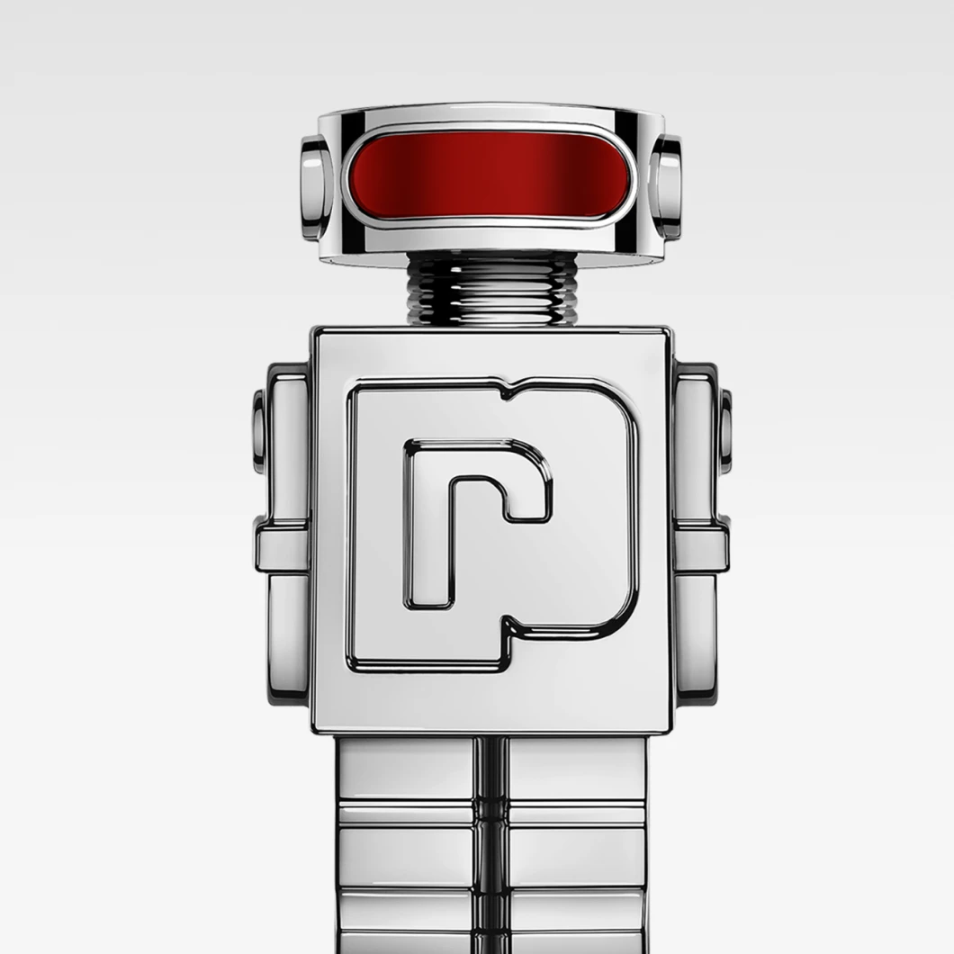 Silverfärgad parfymflaska i robotform med röd detalj upptill mot ljus bakgrund. Designen är geometrisk och metallisk.
