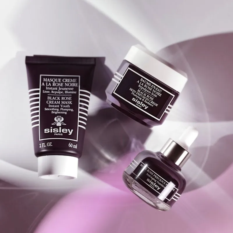 Tre mørke beholdere fra Sisley Paris: "Black Rose Cream Mask", "Black Rose Skin Infusion Cream", "Black Rose Precious Face Oil".
