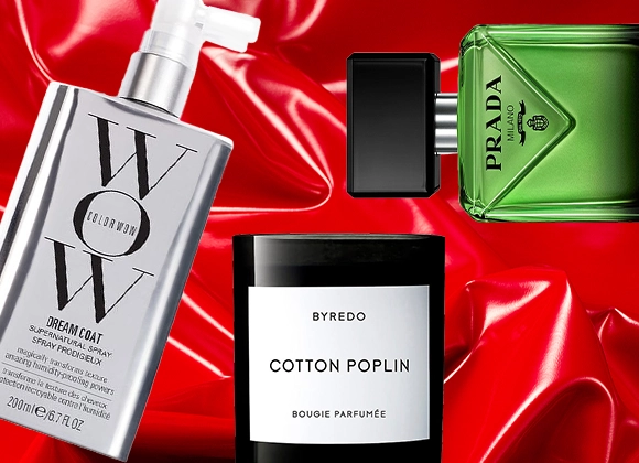 Tre produkter mot en röd bakgrund. En grön parfymflaska från Prada, en silvrig sprayflaska från Color WOW samt ett svart ljus med vit etikett från Byredo